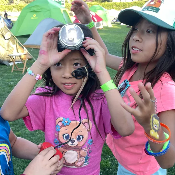 Young campers enjoy testing out a working c. 1959 U.S. Government issue headlamp and battery pack